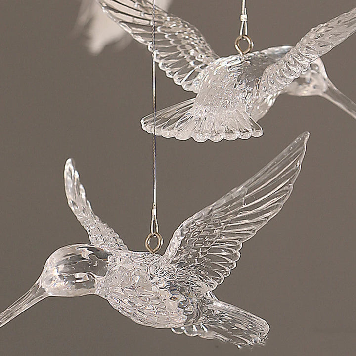 Suspension en plumes blanches pendantes style art déco vintage, ornée d'un oiseau en verre transparent. Parfait pour créer une atmosphère chaleureuse et raffinée dans votre salon ou chambre. Ampoules LED incluses. Tailles disponibles : 70x48 cm, 80x48 cm.