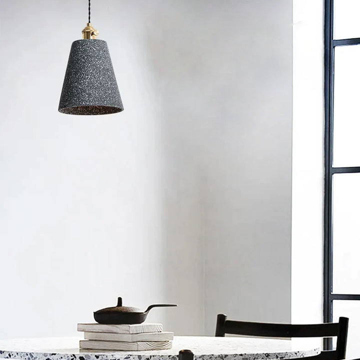 Suspension évasée allongée terrazzo design industriel avec une table, une lampe et une pile de livres