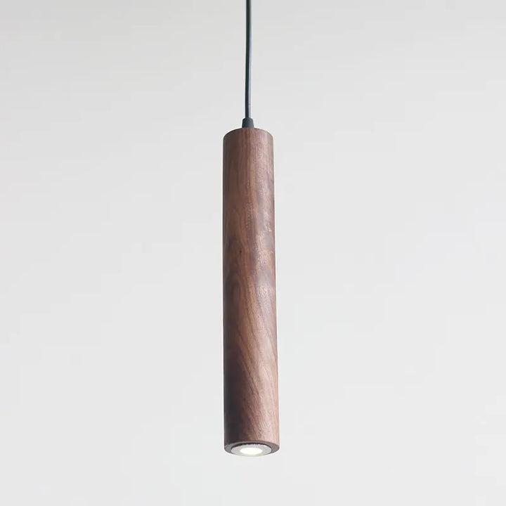 Une suspension en bois de noyer avec trois cylindres minimalistes suspendus, idéale pour les amateurs de design scandinave. Offrant une lumière douce et chaleureuse, cette lampe crée une atmosphère accueillante. Parfaite pour le salon, la salle à manger ou le bureau.