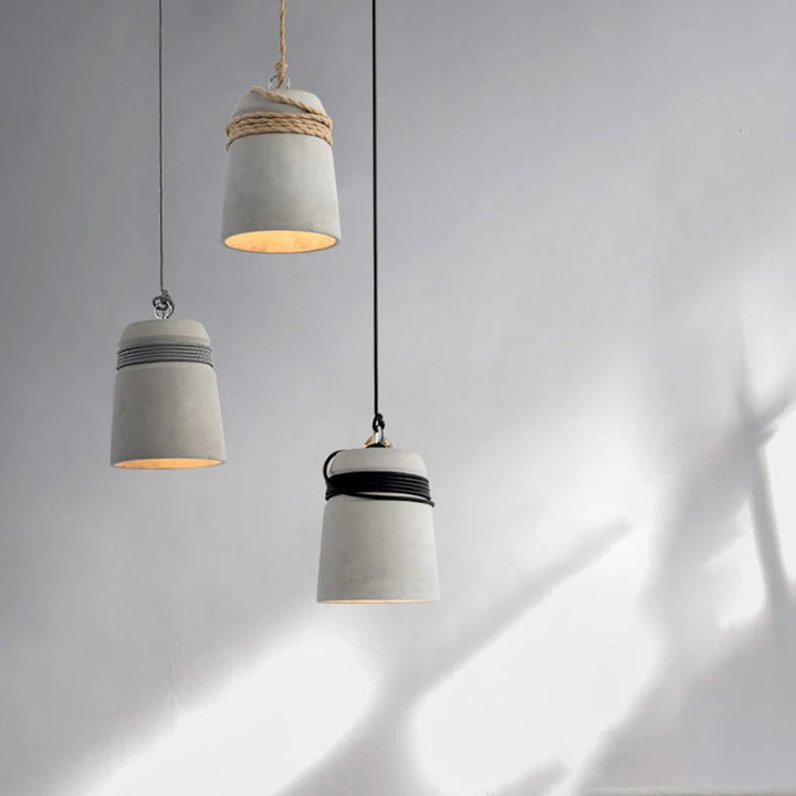 Suspension cloche ciment et corde design scandinave éclairant une pièce avec douceur et naturel. Parfait pour un intérieur nordique et organique.