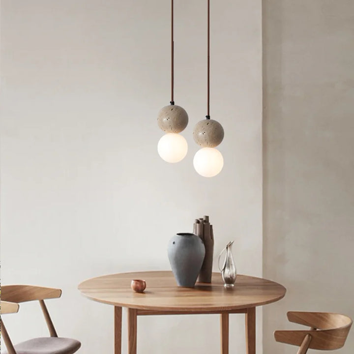 Suspension en pierre naturelle double globe design minimaliste scandinave avec deux lampes sur une table ronde.