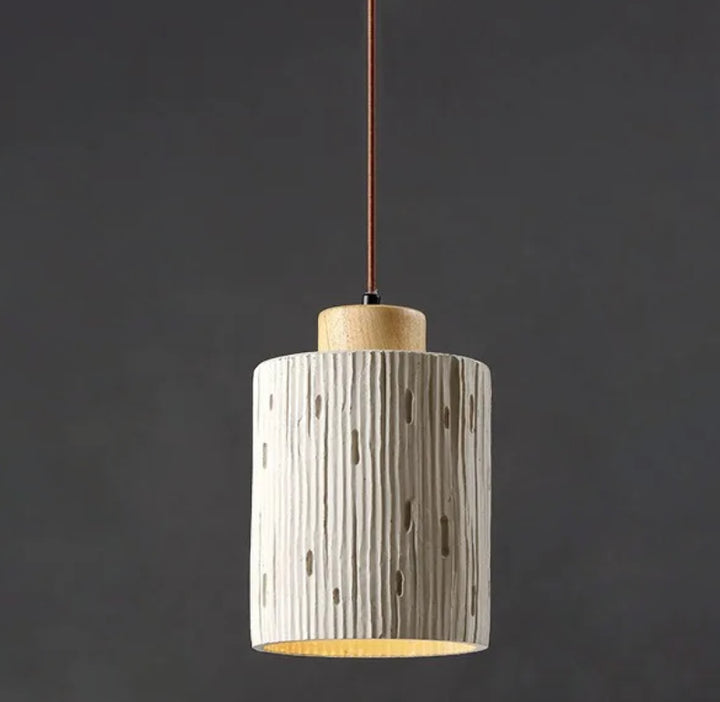 Une suspension cylindre rainuré en terre cuite et bois scandinave, éclairant un espace de 5 à 10 m² avec une lumière accueillante et une esthétique minimaliste et chaleureuse. Ampoule incluse. Parfait pour un intérieur épuré et naturel.