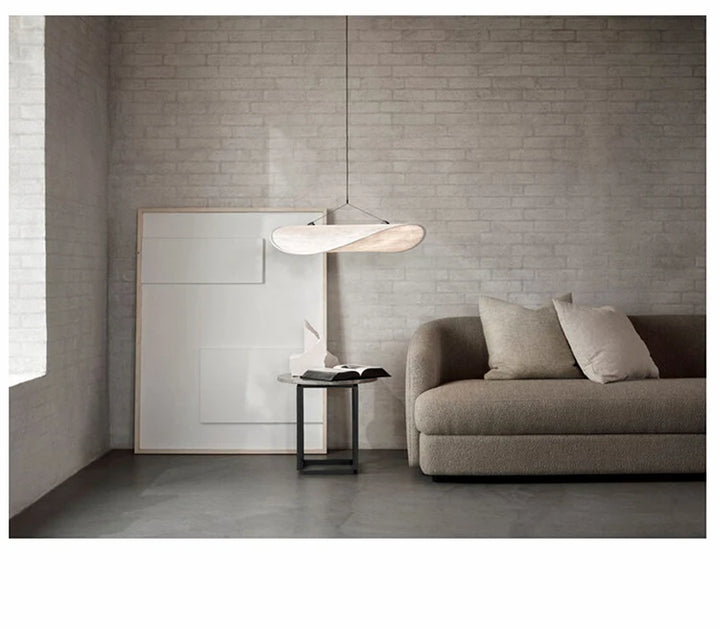 Une suspension moderne vague en tissu blanc avec un canapé et une lampe dans une pièce. Parfait pour un intérieur contemporain ou scandinave. Disponible en différentes tailles et éclairages ajustables.