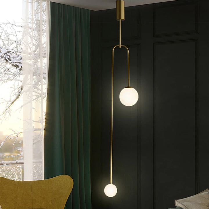 Suspension longue en laiton design moderne avec boules lumineuses, idéale pour illuminer votre intérieur. Disponible en doré ou noir. Ampoule LED incluse. Taille : 16x126 cm. Parfait pour salon ou chambre.