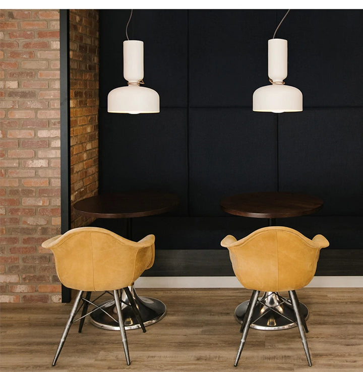 Suspension Diabolo Scandinave Minimaliste - Une table et des chaises dans une pièce, avec une chaise sur un sol en bois et une chaise avec des pieds en métal. Un mur en briques en gros plan et une table en gros plan.