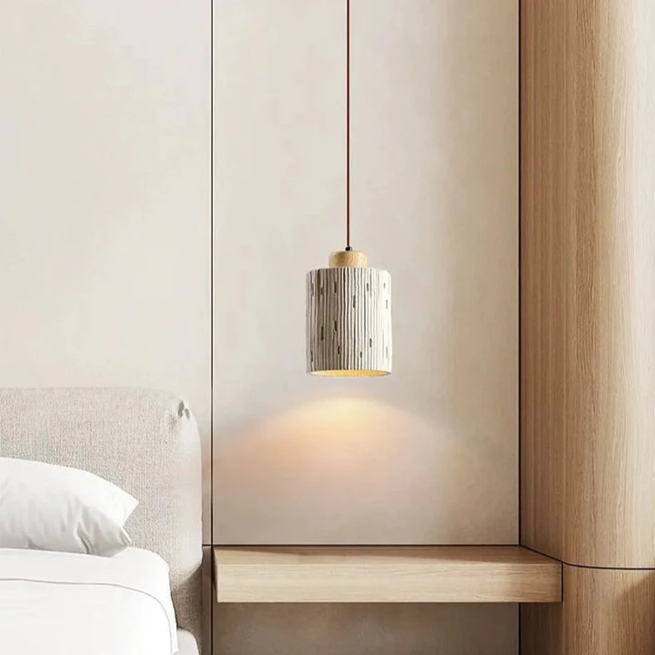 Suspension cylindre rainuré en terre cuite et bois scandinave, éclairage chaleureux pour une décoration intérieure minimaliste et chic.