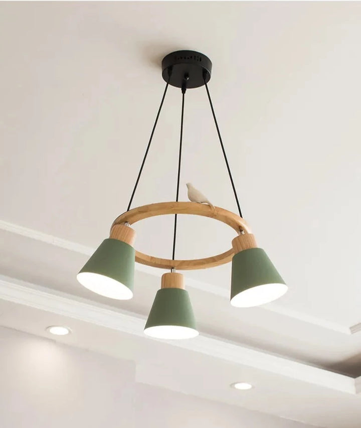 Suspension bois coloré cercle oiseau 3 lampes - Luminaire avec trois abat-jours verts et un oiseau blanc sur un cercle en bois. Parfait pour un éclairage chaleureux et une décoration scandinave contemporaine.