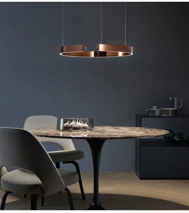 Suspension métal anneau ouvert design moderne avec table ronde et chandelier au plafond, idéale pour créer un point focal dans votre espace intérieur. Disponible en finitions luxueuses et adaptée à tout style. Ampoule LED incluse. Dimensions: 40 cm, 60 cm. Parfait pour le salon ou la cuisine.