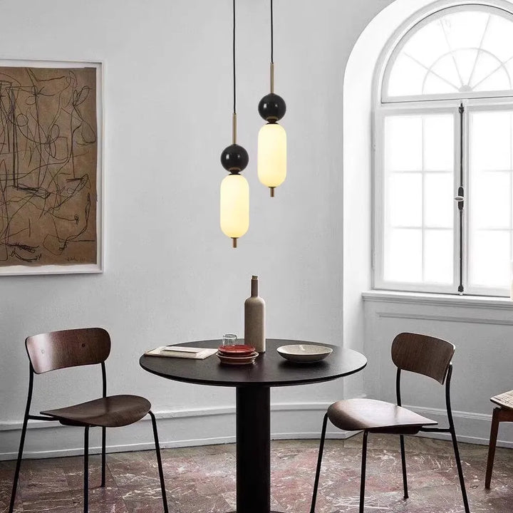 Une suspension moderne bicolore avec boule noire et marbre, s'intégrant parfaitement dans tout intérieur. Idéale pour éclairer votre espace avec style.