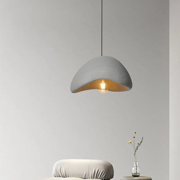 Suspension terre cuite cloche asymétrique scandinave minimaliste éclairant un espace minimaliste avec son effet terre cuite indémodable.