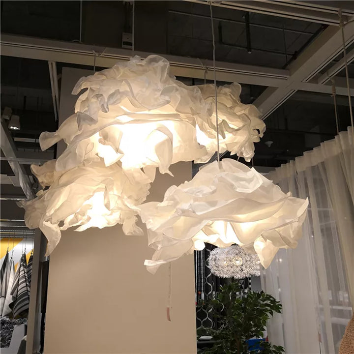 Suspension nuage en papier design vintage avec lumières blanches au plafond, créant une atmosphère douce et poétique. Modulable et unique, cette suspension offre une lumière douce et diffuse, idéale pour les intérieurs épurés ou vintage. Disponible en différentes tailles pour s'adapter à toutes les pièces. Ampoule LED incluse.