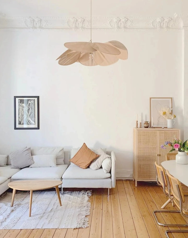 Suspension tissu fleur pétales design vintage bohème éclairant un salon avec canapé et table. Ambiance chaleureuse et élégante pour votre intérieur.