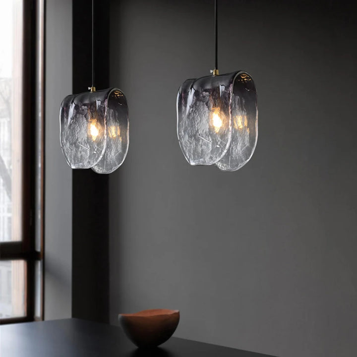 Suspension verre givré gris plié moderne, éclairage contemporain élégant pour espaces de vie de 10-15 m². Ambiance chaleureuse et accueillante avec lumière captée par forme pliée. Taille: 21x17 cm. Ampoule incluse.