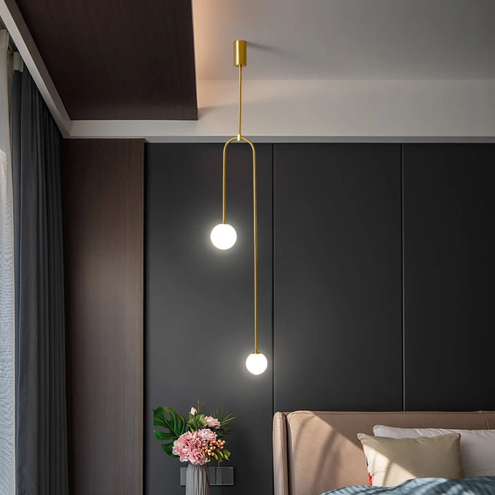 Suspension longue en laiton design moderne avec boules lumineuses aux extrémités. Parfaite pour illuminer votre intérieur avec élégance et simplicité. Ampoule LED incluse. Taille disponible : 16x126 cm.