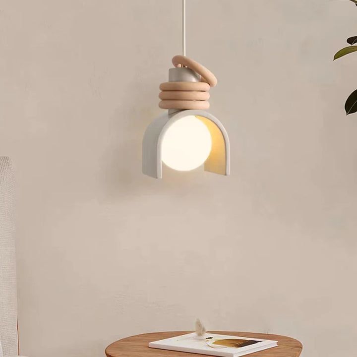 Suspension scandinave terre cuite arc anneaux éclairée par une lampe suspendue au plafond. Ambiance intérieure lumineuse.