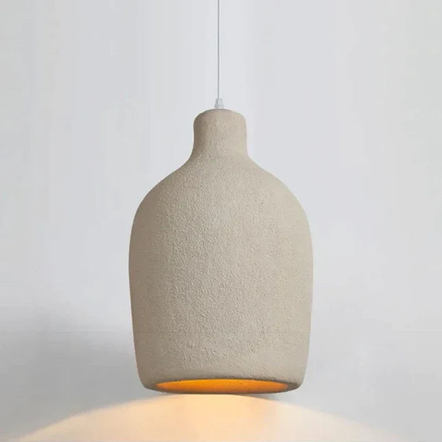 Une suspension cloche en résine effet terre cuite beige bohème avec une ampoule à l'intérieur. Parfaite pour éclairer des zones de 5 à 10 m² dans votre cuisine ou salon. Dimensions : 26x46 cm.