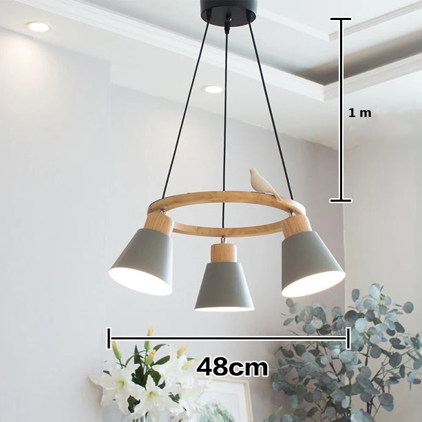 Une suspension en bois avec un cercle orné d'un oiseau, accompagnée de trois lampes colorées. Parfait pour éclairer votre intérieur avec style scandinave. Taille du cercle : 48 cm de diamètre. Taille de la lampe : 15 cm. Ampoule non incluse. Convient pour le salon ou la cuisine. Disponible sur LampeSuspension.com.