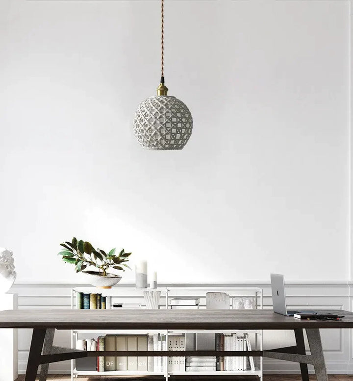 Suspension céramique effet cannage forme boule avec table, livres, plante et ordinateur sur fond. Ajoute une dimension dynamique à votre intérieur avec une atmosphère accueillante et douce. Parfait pour salon ou cuisine. Ampoule incluse.