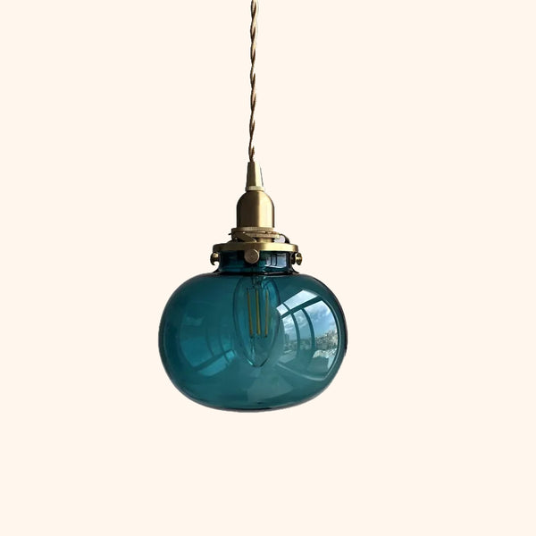 C'est une suspension en forme de petit globe en verre coloré bleu. C'est une suspension rétro avec des détails dorés et un câble tressé. 