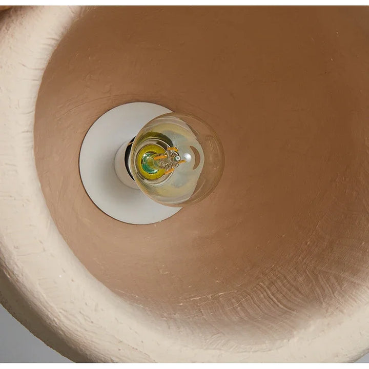 Une lampe suspension avec une ampoule à l'intérieur, effet terre cuite beige bohème. Parfaite pour éclairer des zones de 5 à 10 m². Dimensions : 35x51 cm.