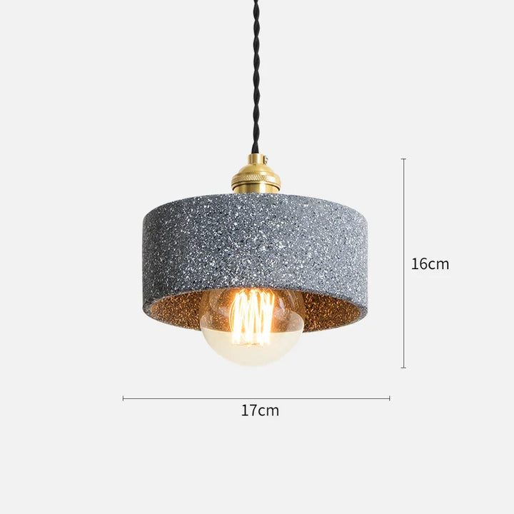 Suspension cylindrique terrazzo industriel avec ampoule. Effet terrazzo finement granulé en gris clair, anthracite ou noir. Câble tressé noir et détails en métal doré. Style contemporain et ambiance loft moderne. Taille: 17x16 cm. Ampoule incluse.