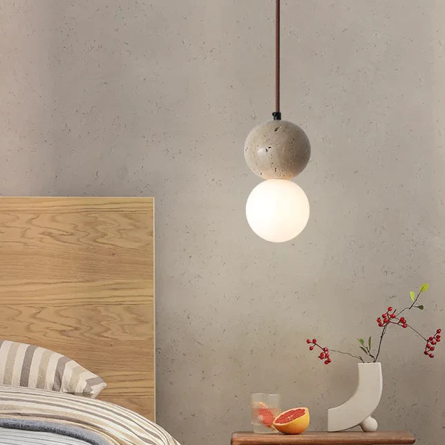 Suspension en pierre naturelle double globe design minimaliste scandinave, éclairant une pièce avec une lumière douce et chaleureuse. Parfait pour créer une ambiance sereine dans votre intérieur.