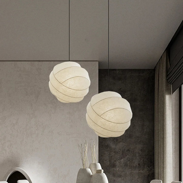 Une suspension sphérique en tissu soie blanc avec des bandes entrelacées, apportant une lumière douce et contemporaine pour votre intérieur. Disponible en deux tailles (30 cm, 40 cm) et avec une ampoule LED intégrée. Parfait pour le salon ou la chambre. LampeSuspension.com