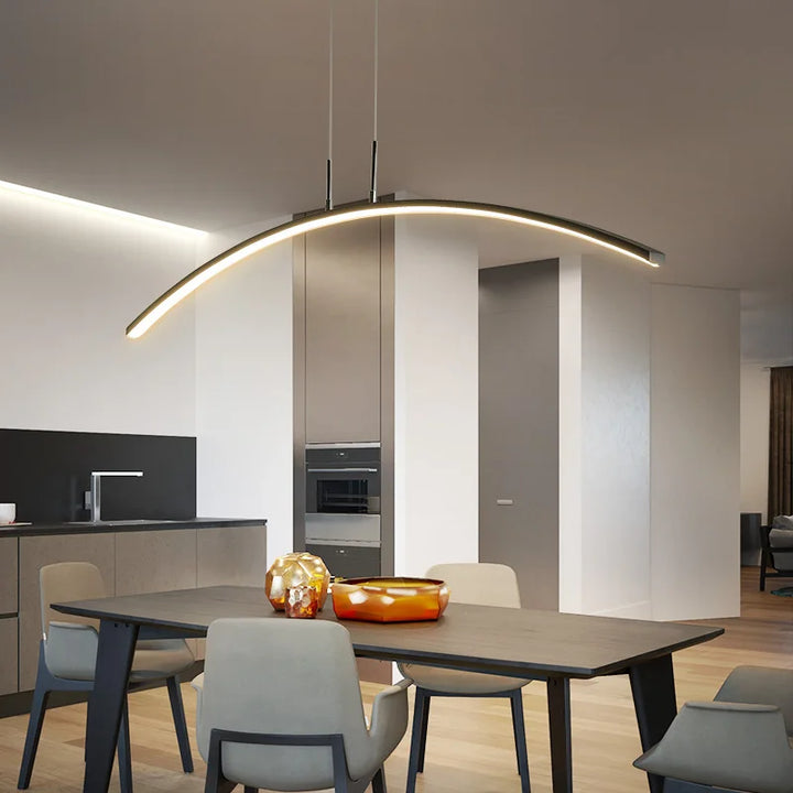 Une table à manger moderne avec une suspension métallique en forme d'arche au-dessus. Parfaite pour ajouter une touche d'élégance contemporaine à votre salon ou cuisine. Ampoule LED incluse. Taille: 120 cm.