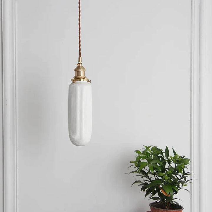 Suspension céramique blanche rainurée et cuivre allongée vintage, éclairage élégant pour tout espace de vie. Design allongé avec rainures délicates, finitions en cuivre pour une touche luxueuse. Idéale pour éclairer des espaces verticaux ou des coins intimistes avec charme intemporel.