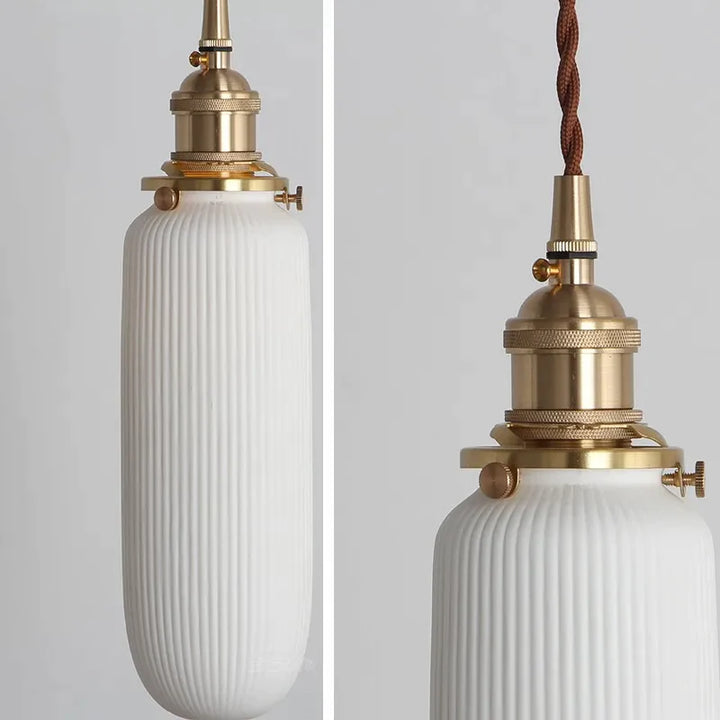 Suspension céramique blanche rainurée et cuivre allongée vintage, éclairage intérieur élégant pour tout espace de vie. Forme élancée avec rainures délicates et finitions en cuivre pour une touche d'élégance vintage. Ampoule LED incluse. Idéale pour éclairer des espaces verticaux ou des coins intimistes avec un charme intemporel. Taille disponible: 7,5x22 cm.