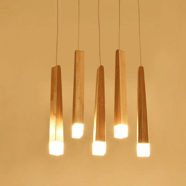 Suspension bois torches suspendues multiples design scandinave avec cinq torches en bois et cubes lumineux LED. Éclairage doux et étendu pour une grande table de salle à manger ou un salon spacieux. Style naturel et moderne. Ampoule LED incluse. Taille torche : 33 cm.