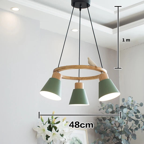 Une suspension en bois avec un cercle coloré et un oiseau, accompagnée de trois lampes. Parfait pour éclairer et décorer votre intérieur avec une touche ludique et scandinave. Taille cercle : 48 cm de diamètre, taille lampe : 15 cm. Ampoule non incluse. Convient pour le salon et la cuisine. Disponible sur LampeSuspension.com.